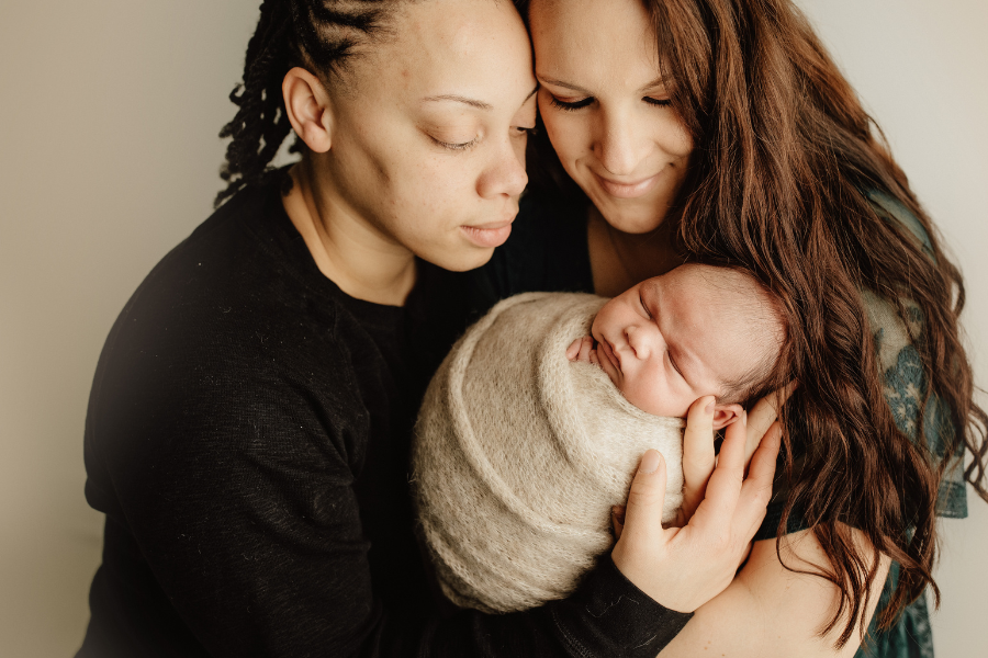 Female couple holding a a new born baby